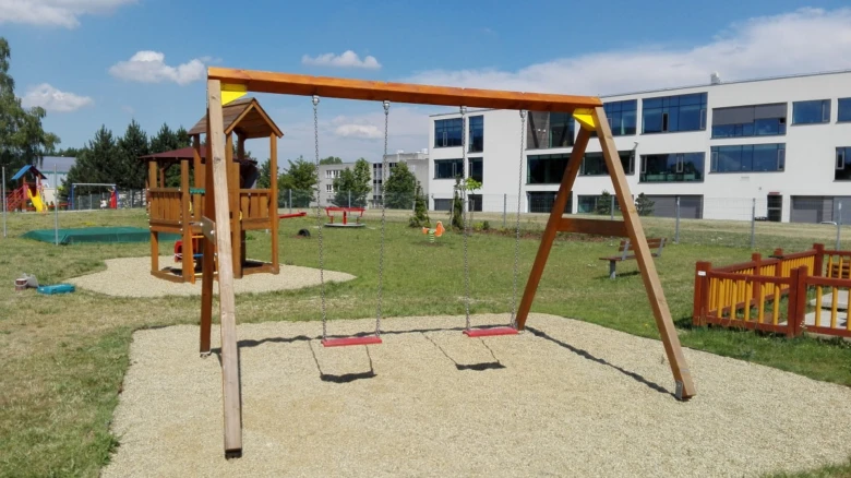 Hřiště s dřevěným houpačkou na štěrku jako povrchové materiály.