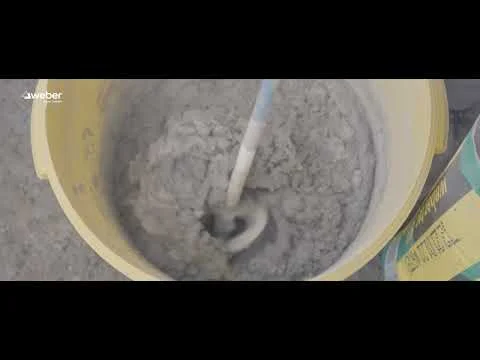 Směšování izolační směsi v žlutém kbelíku pro izolaci sklepa.