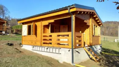 Nově postavený dřevěný dům na svahu s betonovým základem.