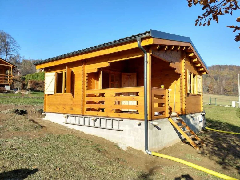 Nově postavený dřevěný dům na svahu s betonovým základem.