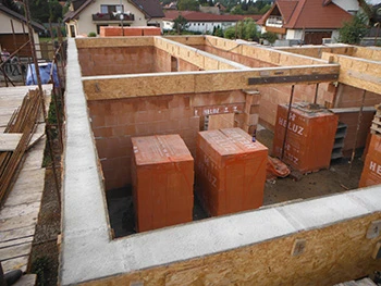 Stavba zděných stěn s betonovými podlahami v domovní konstrukci.