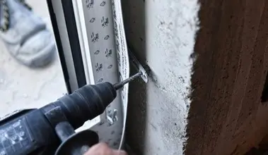 Montážní pásek se šroubuje do betonu při instalaci okna.