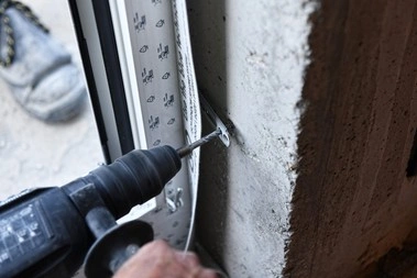 Montážní pásek se šroubuje do betonu při instalaci okna.
