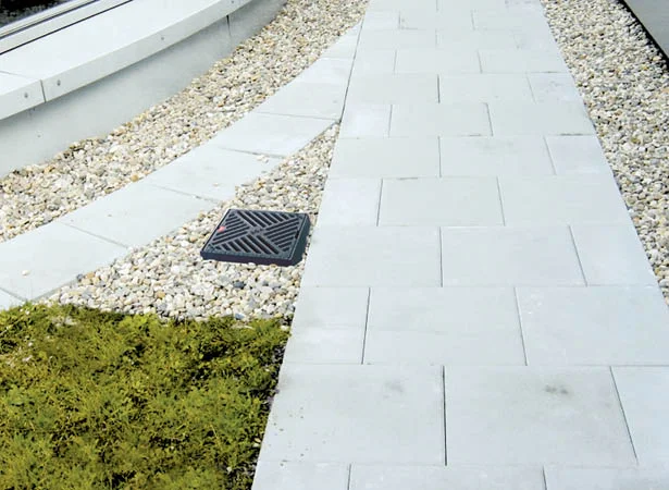 Detail instalace odvodňovací vpusti na okraji ploché střechy.