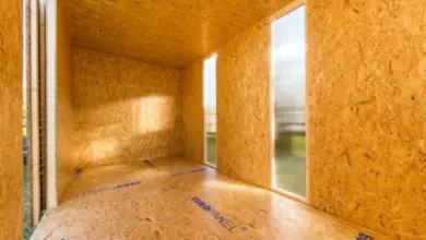 Vnitřek domu z OSB panelů během stavby s okny a podlahou.