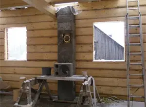 Instalace komínu z nerezové oceli v dřevěném domě.
