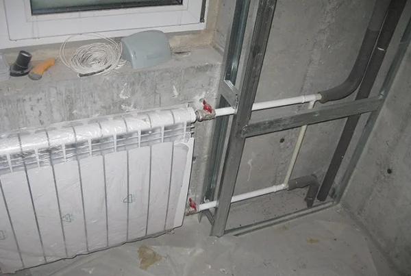 Instalace topných trub s radiátorem v průběhu stavebních prací.