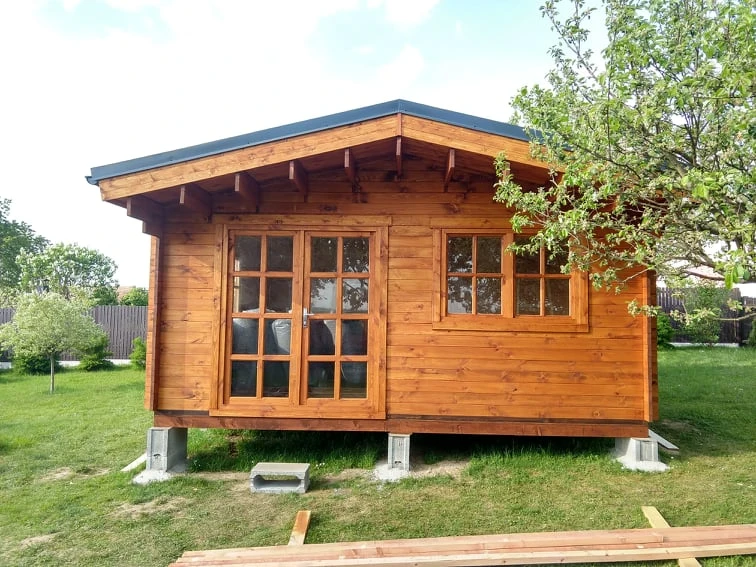Dřevěný domek na betonových blokách pro svahovou základnu.