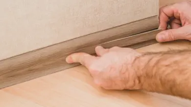 Ruční instalace dřevěné lišty podlahy k zemi.