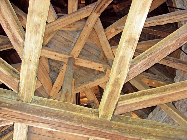 Detail dřevěného krokvového systému v konstrukci střechy.