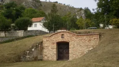Vstup do vinného sklepu z kamene ve svahu.