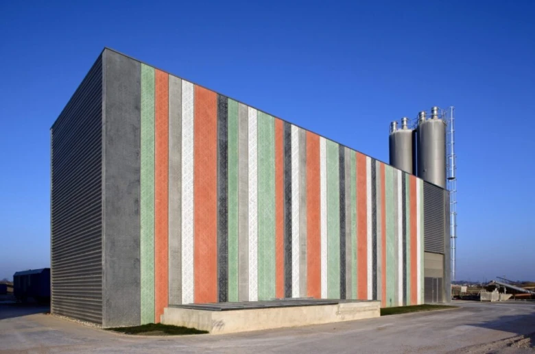 Moderní budova s barevnými betonovými panely ve vertikálních pruzích.