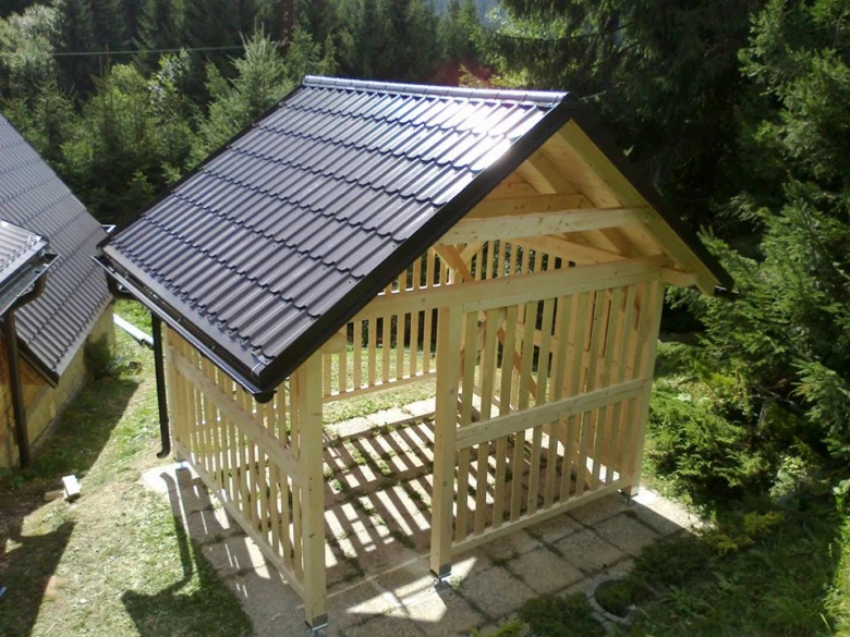 Nově postavený dřevěný altán s nainstalovanou tmavou střechou.