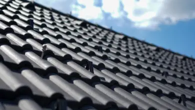 Detailní pohled na tmavé střechové tašky s překrývajícím se vzorem.