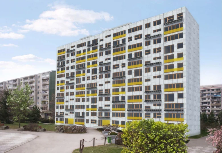 Modernizovaný panelový dům s žlutými prvky na fasádě.