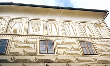 Historická budova v Praze se sgrafitovou výzdobou fasády