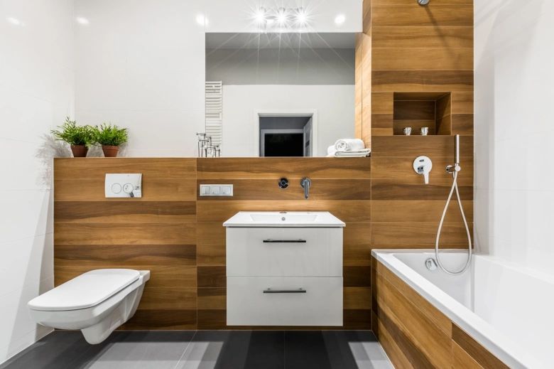 Moderní koupelna s dřevěnými obklady a dlažbou jako vhodné materiály.