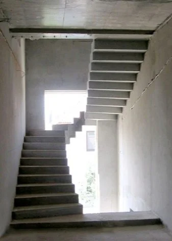 Nezhotovené betonové schodiště v budově ve stavbě.
