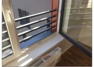 Instalace bílého parapetu pod oknem v interiéru bytu.