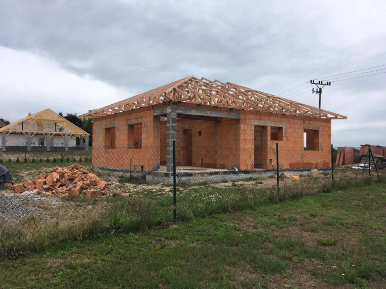 Stavba domu z cihel a plynosilikátových bloků na pozemku.
