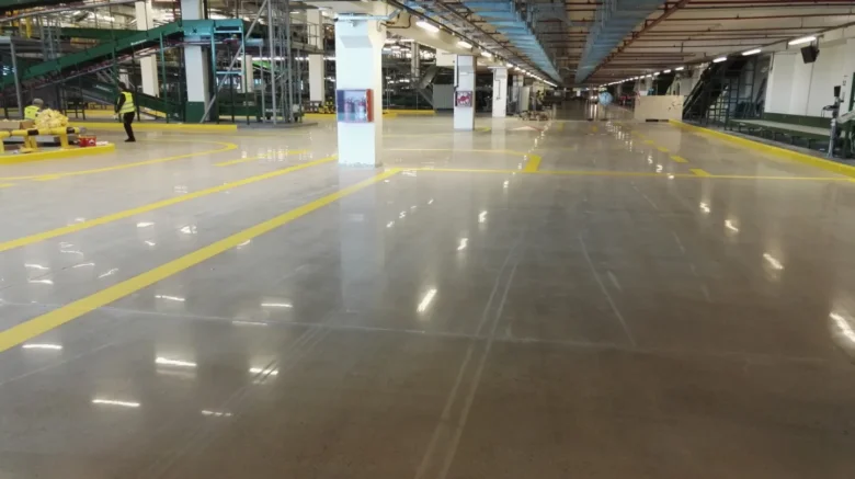 Lesklá betonová podlaha v průmyslovém prostoru po úpravách.