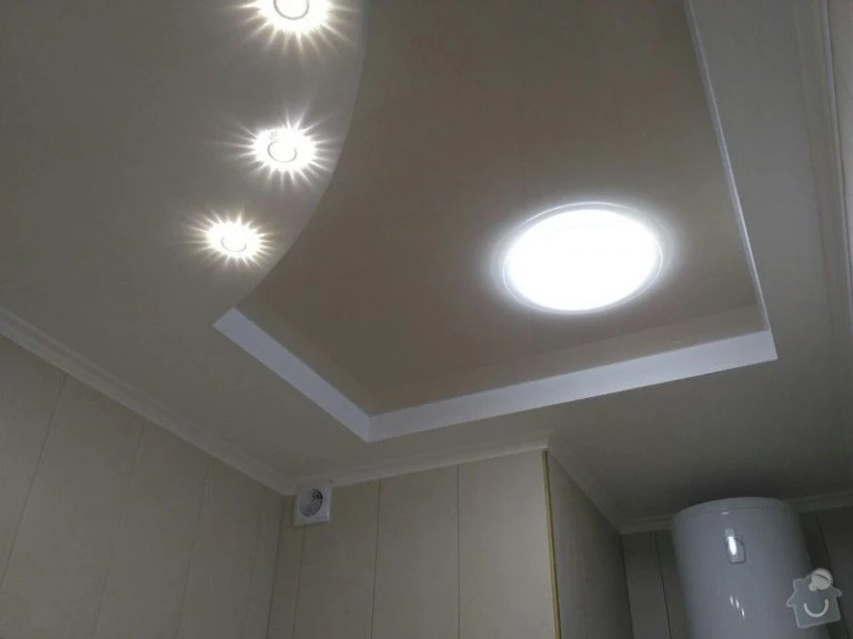 Moderní koupelnový strop s vestavěnými světly a dekorativním rámečkem.