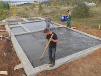 Muži zalisují betonovou desku pro monolitické základy.