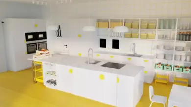 Moderní bílá kuchyň s žlutými detaily v interiéru.