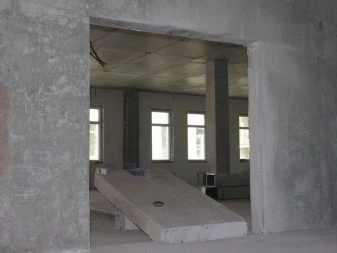 Rozšířený otvor dveří v bytovém domě s betonovými stěnami.