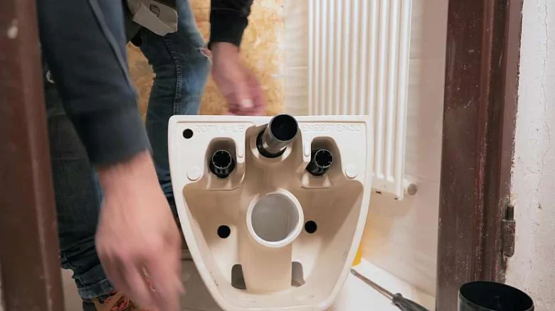 Podstavec suché toalety s viditelnými připojeními pro instalaci.