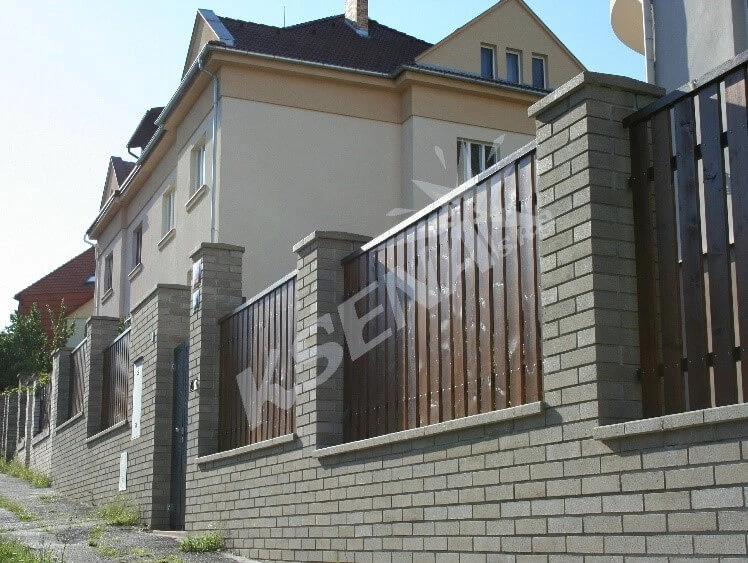 Zděný plot s dřevěnými lamelami u rodinného domu v roce 2024.