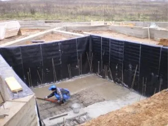 Stavebník nalévá betonovou podlahu do suterénu.